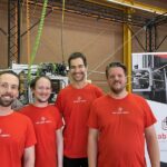 four men in red t-shirts